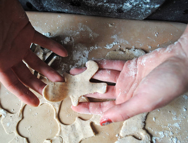 Процесс приготовления имбирного печенья. Девочка готовит печенье. Глютен без рисовой муки. Домохозяйка печет рождественское печенье. Крупный план
 - Фото, изображение