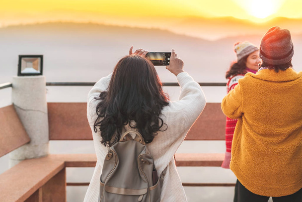 TAILANDIA DE LÁMFONO - 9 DE DICIEMBRE: Turistas no identificados tomando fotos y selfies mientras sale el sol el 9 de diciembre de 2019 en Wat Phra Phutthabat Pha Nam en Lamphun, Tailandia - Foto, imagen