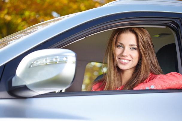 Beautiful young sexy woman in car looking from window on autumn - Foto, Bild