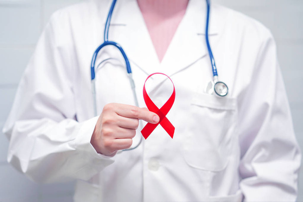 Doctor holding red ribbon. AIDS, HIV - Φωτογραφία, εικόνα