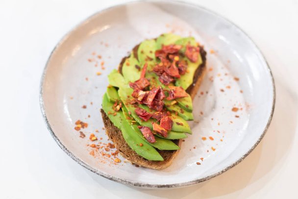 Sliced fresh avocado toast bread with spices. Healthy vegan or v - Foto, afbeelding