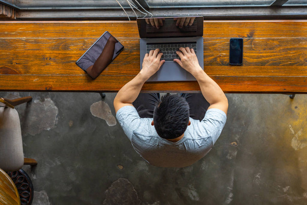 High angle view of Asian businessman working on laptop  - Fotó, kép