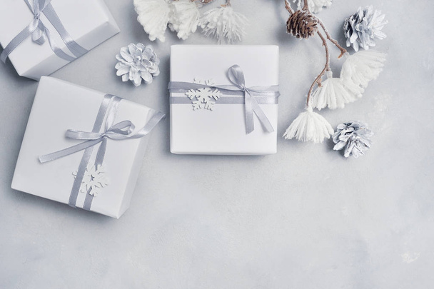 Border Design a Christmas greeting card with Xmas gift box, cones, snowflakes with place for your text. Decorations on a white concrete background - Fotoğraf, Görsel
