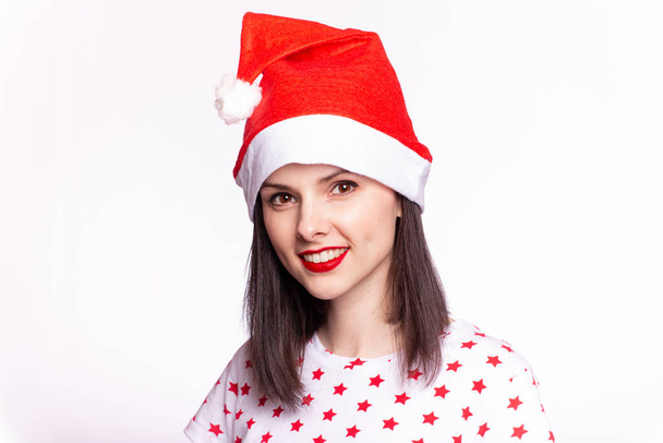 beautiful girl in a t-shirt with a star and a santa claus hat, with red lipstick on her lips - Photo, Image
