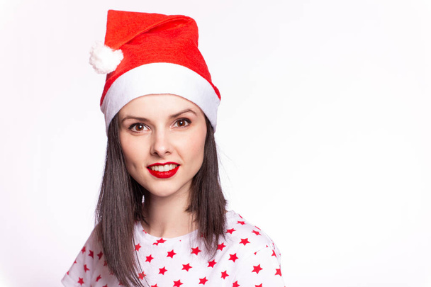 beautiful girl in a t-shirt with a star and a santa claus hat, with red lipstick on her lips - Foto, Imagem