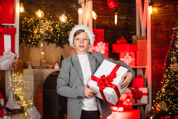 teen boy help santa with presents. visit santaland this holiday. winter wonderland in north pole. small boy celebrate new year in residence of santa. childhood dream. best xmas gift - Foto, Bild