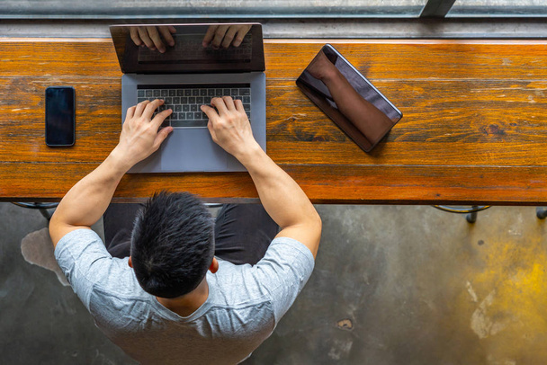 Asian freelancer typing laptop next to tablet and smart phone - Φωτογραφία, εικόνα