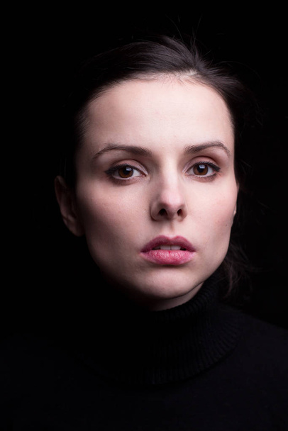 emotional girl in a black turtleneck on a black background - Fotografie, Obrázek