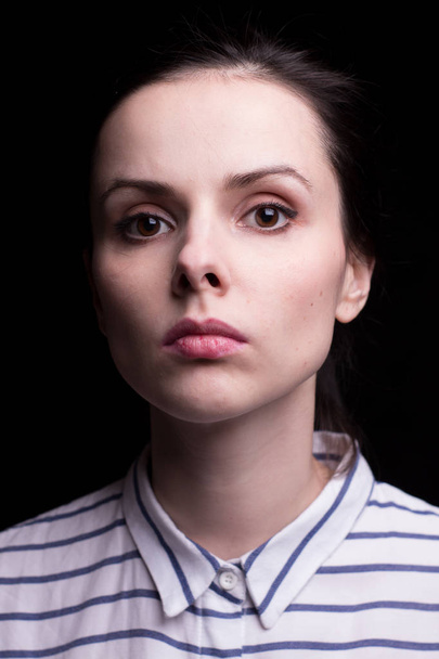 emotional girl in a striped shirt on a black background - Photo, image