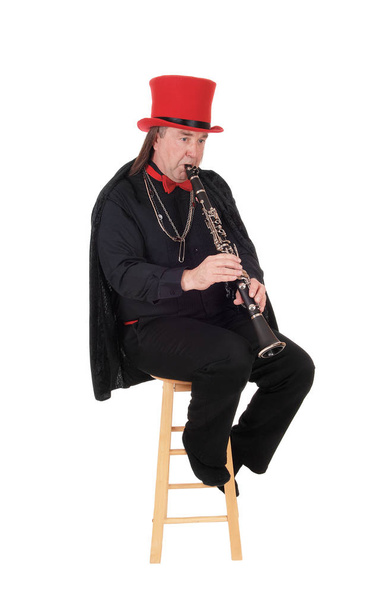 A clarinet player with a red hat and black outfit - Fotoğraf, Görsel
