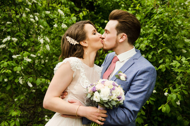 Наречений і наречений в парку цілує.Пара молодих наречених і наречених на весіллі в природі зелений ліс цілує фотопортрет. Весільна пара
 - Фото, зображення