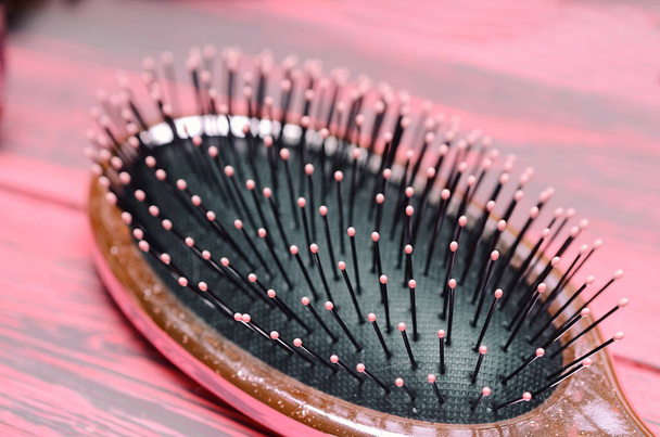 pink hairbrush close up on a pink wooden background - Foto, afbeelding