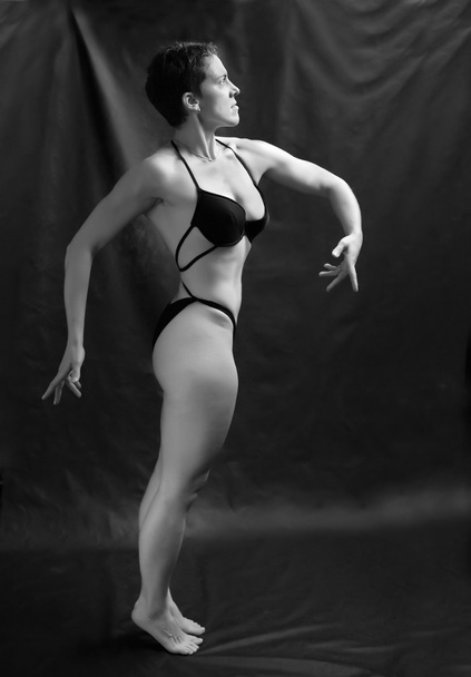 Body builder donna posa su sfondo nero
. - Foto, immagini