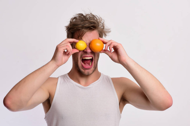 Athlete with messy hair holds fresh fruit. Man with fruit - 写真・画像