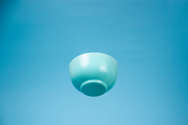 Niebieski ceramiczny matowy głęboki miska dla śniadania latającego na błękitnym bac - Zdjęcie, obraz