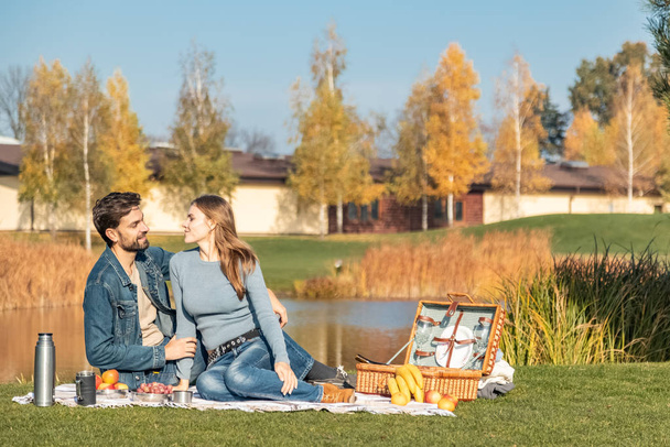 Young loving couple having a picnic outdoors - Φωτογραφία, εικόνα