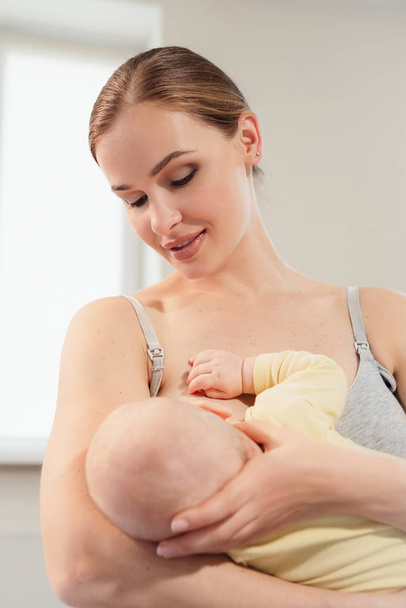 moeder borstvoeding baby thuis. Borstvoeding moeder met klein kind - Foto, afbeelding