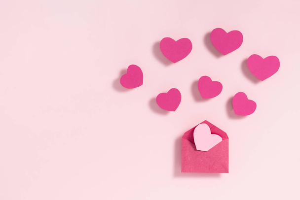 Valentin napi keret kompozíció. Lila rózsaszín szív üres papírlap pasztell rózsaszín háttér. Felülnézet, lapos fekvés, másolás - Fotó, kép