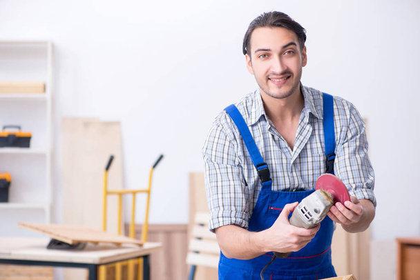 Joven carpintero masculino trabajando en interiores - Foto, Imagen