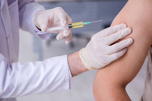 Mužský pacient na návštěvě lékaře na očkování injekce - Fotografie, Obrázek