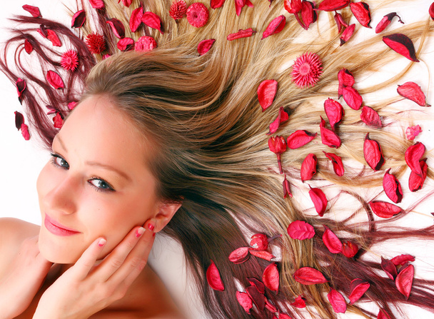 Красива молода жінка з квітами на довге волосся
. - Фото, зображення
