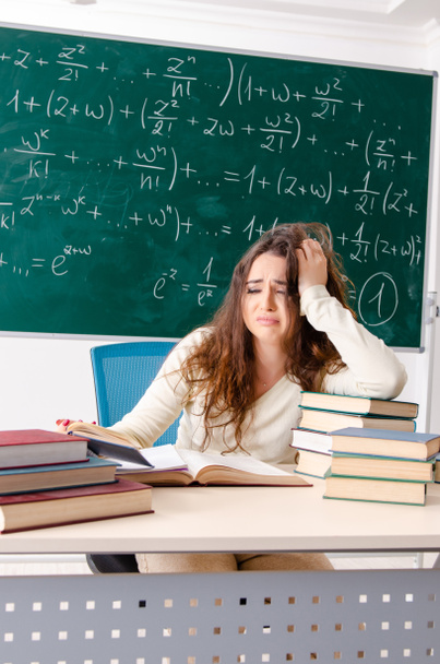 Jonge vrouwelijke wiskundeleraar voor schoolbord - Foto, afbeelding
