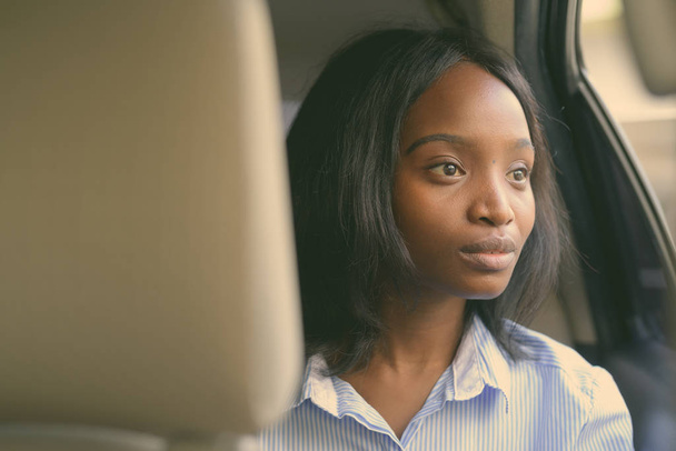 Young beautiful African Zulu businesswoman riding inside the car - Photo, Image