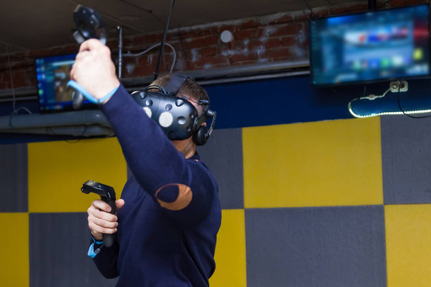 Ο τύπος παίζει έναν αγώνα που συνδέεται με την εικονική πραγματικότητα σε ένα κράνος w - Φωτογραφία, εικόνα