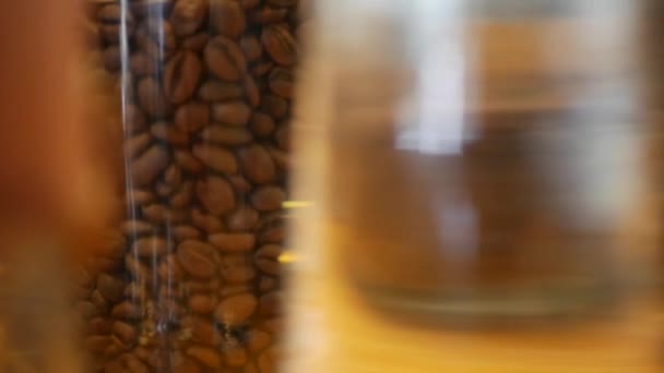 Vele soorten koffiebonen in glazen potten op een houten tafel in een café. Close-up  - Video