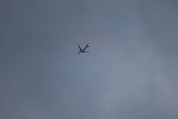 Bílé osobní letadlo v mracích při západu slunce.Letadlo na obloze a mrak při východu slunce - Fotografie, Obrázek