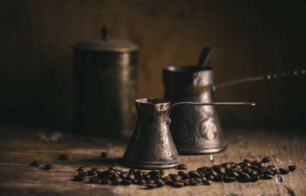Vecchia caffettiera e chicco di caffè su tavolo rustico in legno. Vintage o
 - Foto, immagini