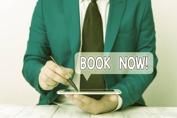 Text sign showing Book Now. Conceptual photo guaranteed to have place because you have already purchased it Businessman pointing with pen in empty copy space. - Photo, Image