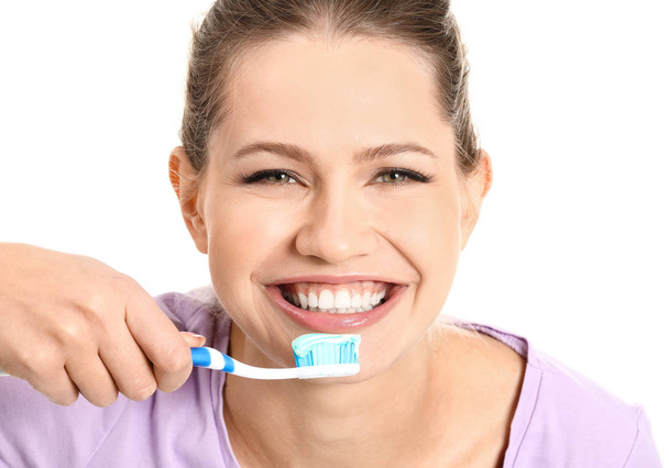 Jovem mulher escovando os dentes no fundo branco - Foto, Imagem