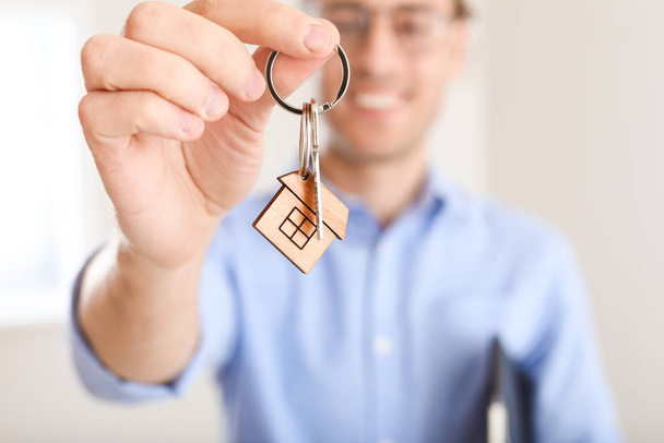 Male real estate agent with key indoors, closeup - Foto, Bild