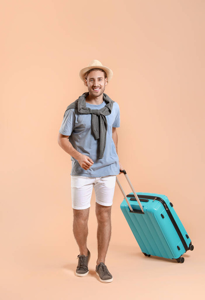 Молодой турист с багажом на цветном фоне
 - Фото, изображение