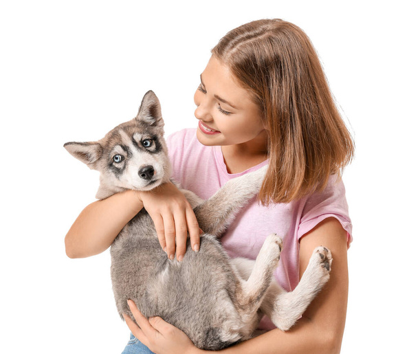 Cute teenage girl with funny husky puppy on white background - Фото, зображення