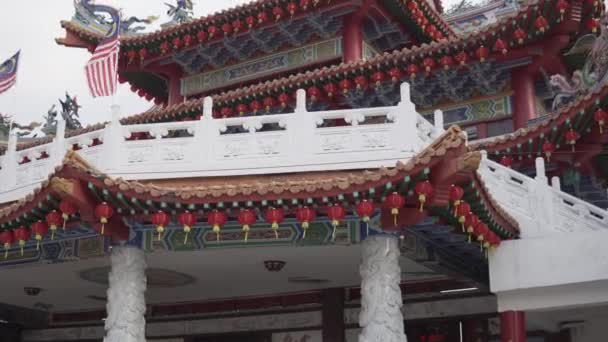 Buddyjska kamera Świątynna Thean Hou dryfuje w prawo. Flagi amerykańskie i malezyjskie w tle na szczycie pierwszego poziomu świątyni. - Materiał filmowy, wideo