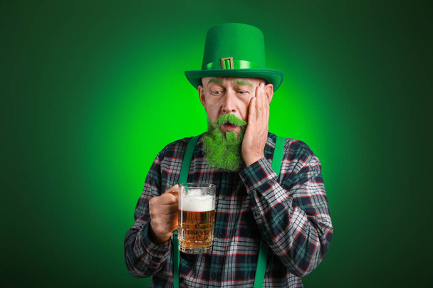 Funny mature man with glass of beer on dark background. St. Patrick's Day celebration - Photo, Image