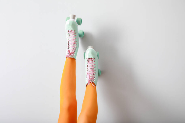 Legs of woman in roller skates against white wall - Fotoğraf, Görsel
