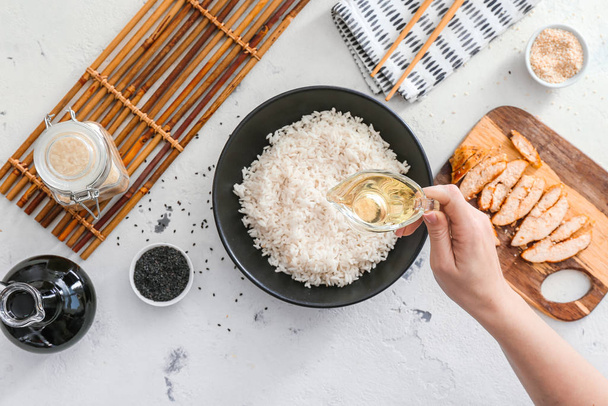 Mulher preparando arroz saboroso com frango
 - Foto, Imagem