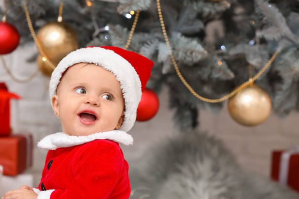 Mignon petit bébé en costume de Père Noël la veille de Noël à la maison
 - Photo, image