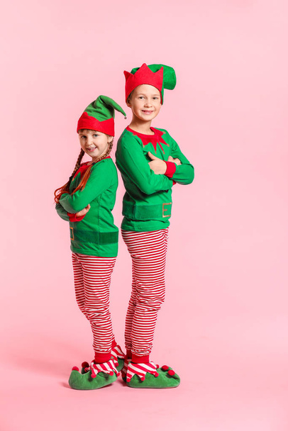 Little children in costume of elf on color background - 写真・画像