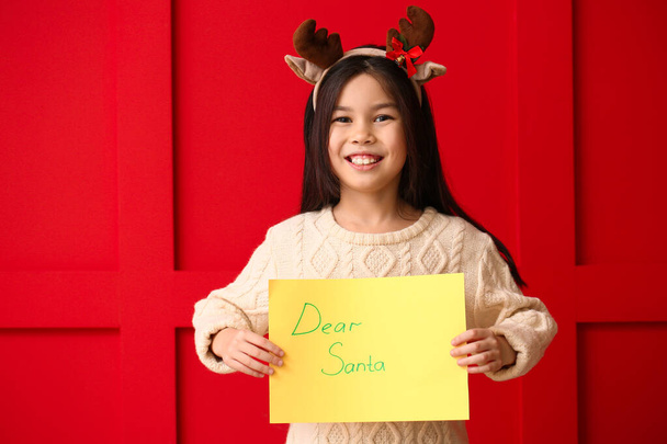 Cute little girl with letter to Santa Claus on color background - Foto, immagini