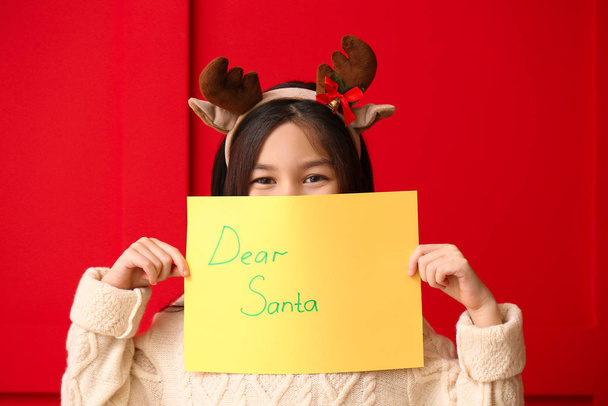 Cute little girl with letter to Santa Claus on color background - Fotografie, Obrázek