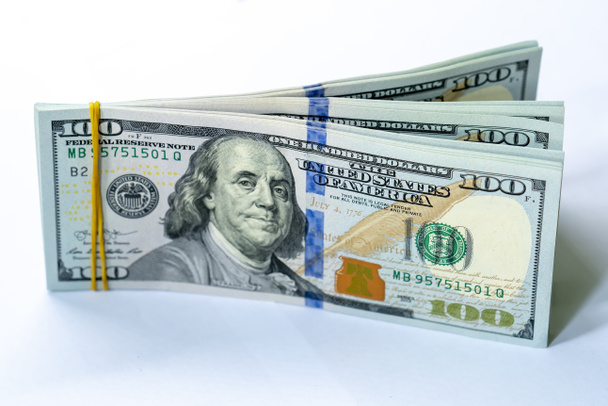 Stapel von 100-Dollar-Banknoten auf isoliertem weißem Hintergrund. Geschäfts- und Finanzierungskonzept. - Foto, Bild