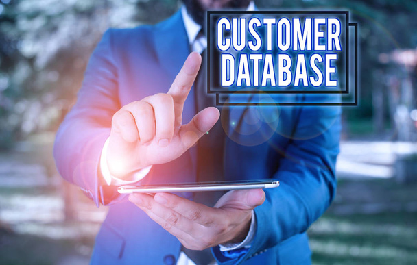 Text sign showing Customer Database. Conceptual photo uptodate on customer information records and data Businessman in blue suite with a tie holds lap top in hands. - Photo, Image