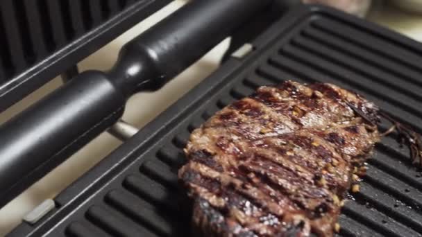 Steak de bœuf appétissant prêt à manger. Viande marinée aux herbes sur un gril électrique à la maison
.  - Séquence, vidéo