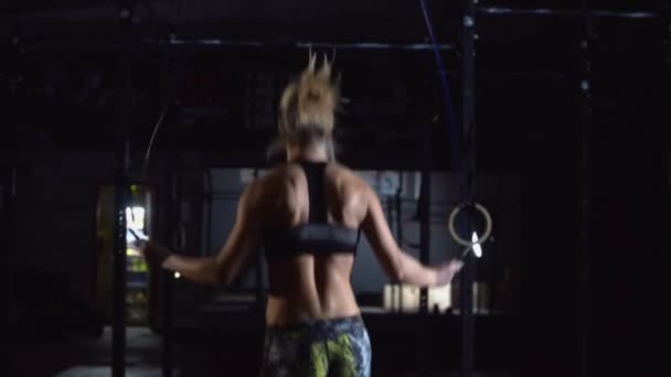 Athlétique belle femme portant des vêtements de sport exercices avec corde à sauter dans la salle de gym hardcore. - Séquence, vidéo