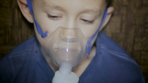 The boy is breathing through the inhaler - Imágenes, Vídeo