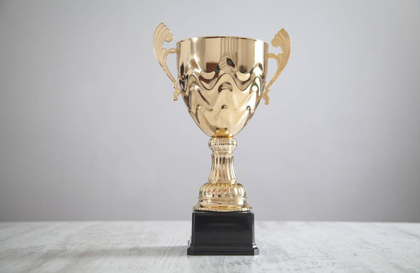  Золотой трофей на белом столе. Бизнес, успех - Фото, изображение